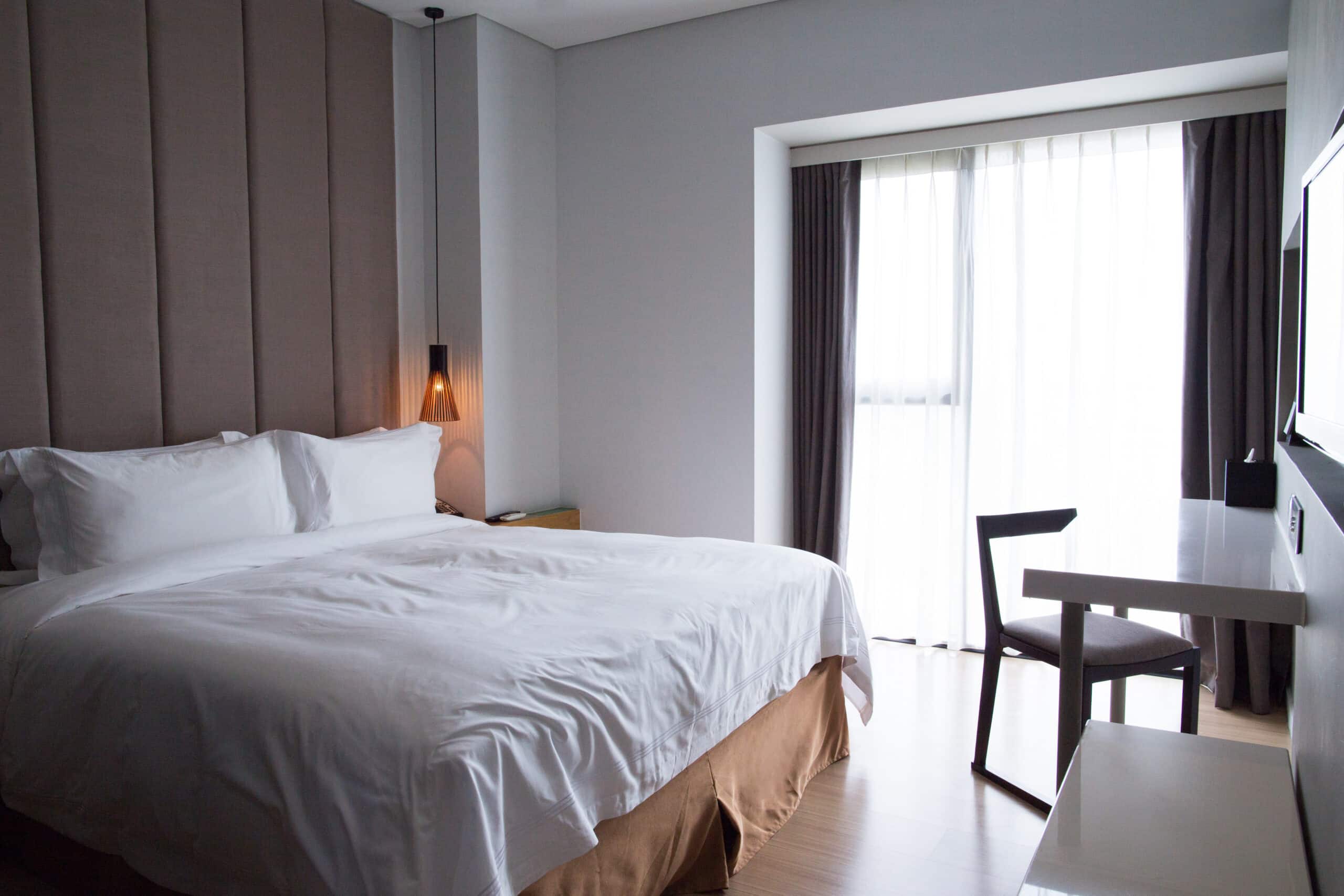 Hotel bedroom with double bed, table and TV set